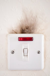 Photograph capturing the damage caused to an electrical point by faulty wiring.